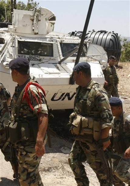  AP Photo Lebanese army soldiers, pass in front of a damaged armored personel carrier of the French UN peacekeepers, in Touline village, south of Lebanon, on Saturday July 3, 2010. A Lebanese military official says southern Lebanese villagers attacked a U.N. patrol with stones and eggs after the peacekeepers detained a villager. An Associated Press photographer saw at least one peacekeeper and one villagers slightly injured.