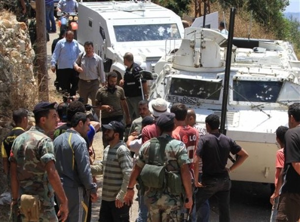  AP Photo Lebanese army soldiers and villagers, stand in front of damaged armored vehicles of the French UN peacekeepers, in Touline village, south of Lebanon, on Saturday July 3, 2010. A Lebanese military official says southern Lebanese villagers attacked a U.N. patrol with stones and eggs after the peacekeepers detained a villager. An Associated Press photographer saw at least one peacekeeper and one villagers slightly injured.