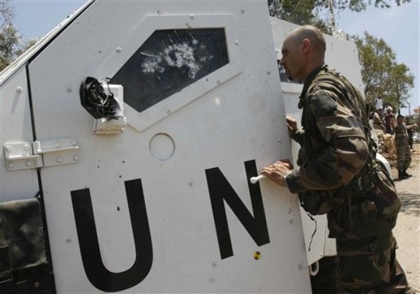  AP Photo A French UN peacekeeper soldier, closeS the damaged door of his armored vehicle, in Touline village, south of Lebanon, on Saturday July 3, 2010. A Lebanese military official says southern Lebanese villagers attacked a U.N. patrol with stones and eggs after the peacekeepers detained a villager. An Associated Press photographer saw at least one peacekeeper and one villagers slightly injured.